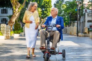 Elderly man on the ATTO mobility scooter with a woman