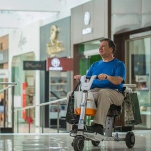 Man is sitting in an ATTO mobility scooter in a mall