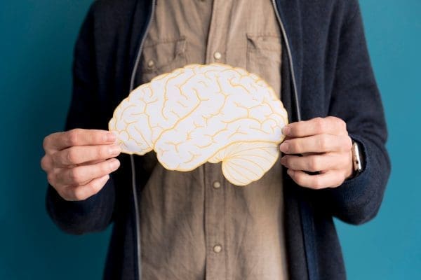 6 close up man holding paper brain scaled 1