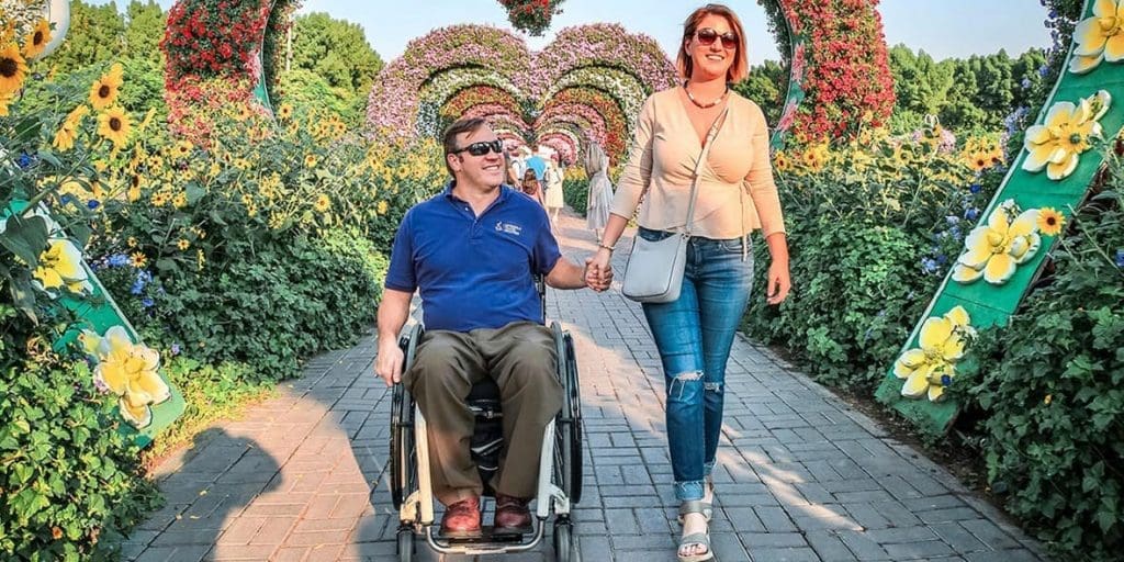 Man in wheelchair holding hands with women